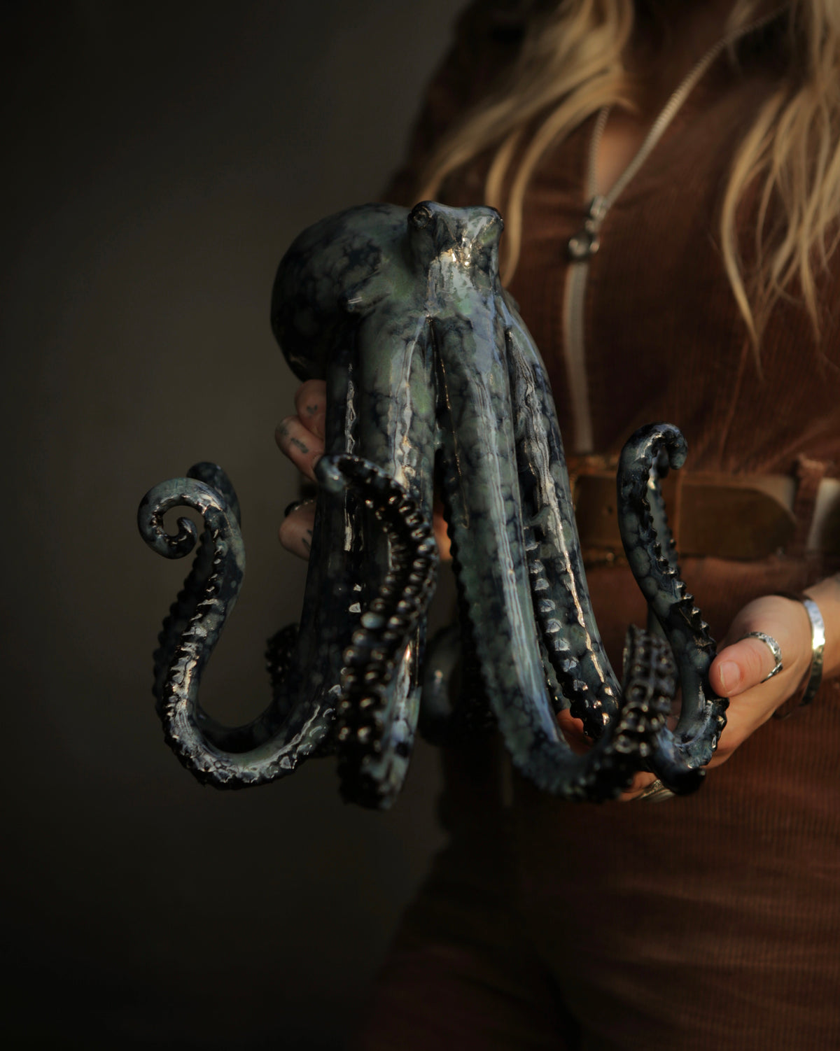 Dark glazed ceramic octopus by Mia Alajasko held in two hands