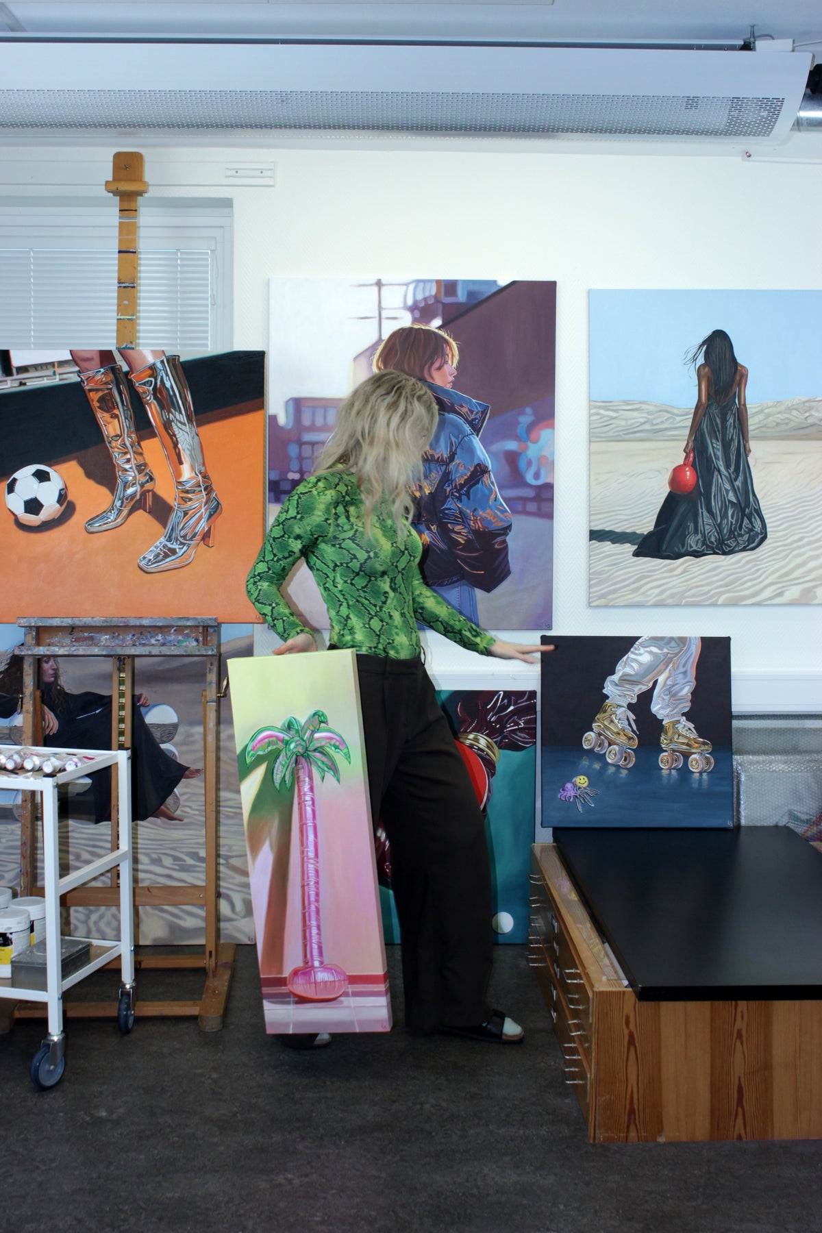 Lovisa Sköld in her studio among her oil paintings